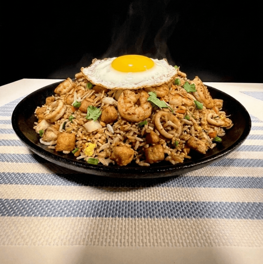 Nasi rice topped with a fried egg, served on a black plate